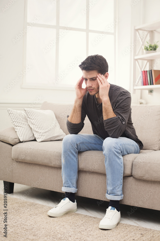 Young man having headache at home Young man having headache at home