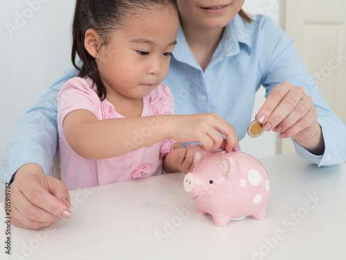 mother teach her kid to saving money.