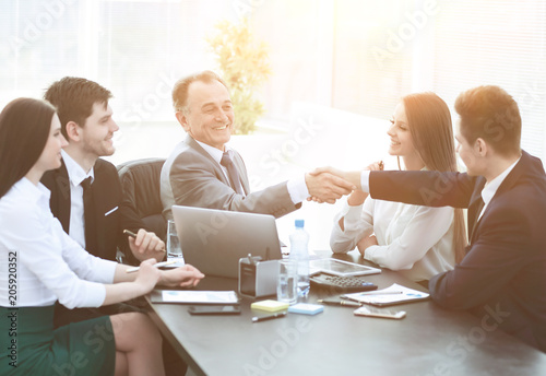 Obraz na płótnie businessman and investor shake hands at the negotiating table w salonie