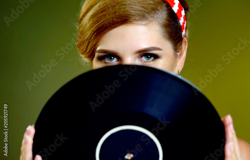 Retro woman with music vinyl record. Pin-up retro female style. Pin-up portrait of girl style wearing red dress. Purchase of antiques. photo