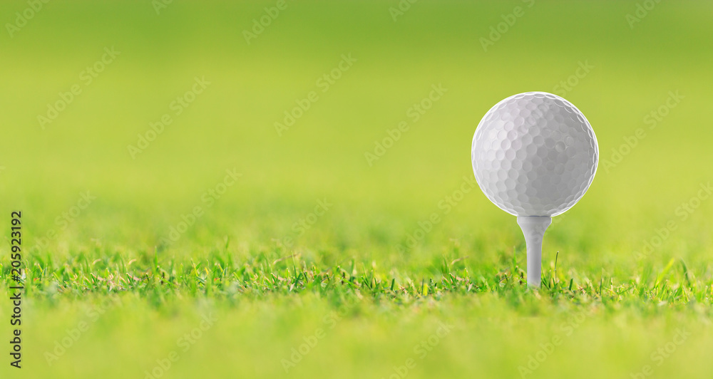 Golf ball on tee on green grass, golf court Golf ball on tee on green grass, golf court