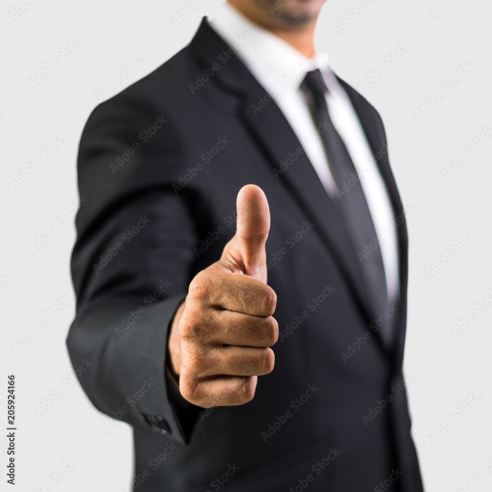 Happy businessman with thumbs up gesture, islated on grey background Happy businessman with thumbs up gesture, islated on grey background