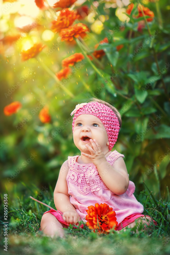 a little girl sitting on the grass with a flower in her hands a little girl sitting on the grass with a flower in her hands
