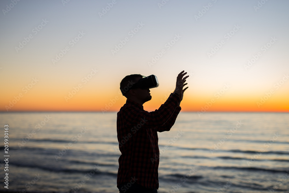 Man using virtual reality glasses on over beautiful sky and sea background