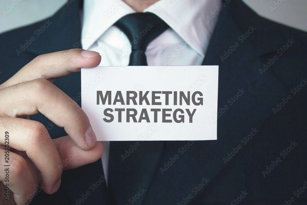 Businessman showing text Marketing Strategy on business card. Businessman showing text Marketing Strategy on business card.