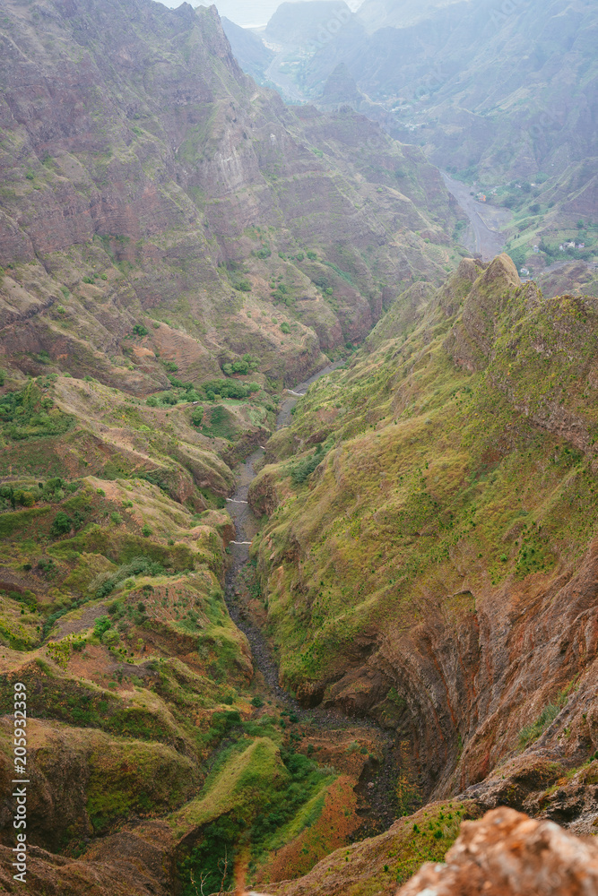Breathtaking view of canyon with steep cliff and winding riverbed with lush green vegetation on Delgadinho mountain ridge. Santo Antao, Cape Verde Breathtaking view of canyon with steep cliff and winding riverbed with lush green vegetation on Delgadinho mountain ridge. Santo Antao, Cape Verde