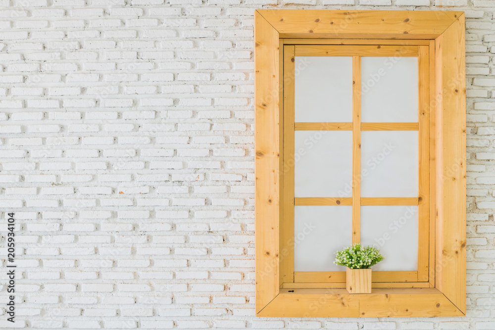 Fototapeta premium Brown wooden glass window with flowers inside on the white facade