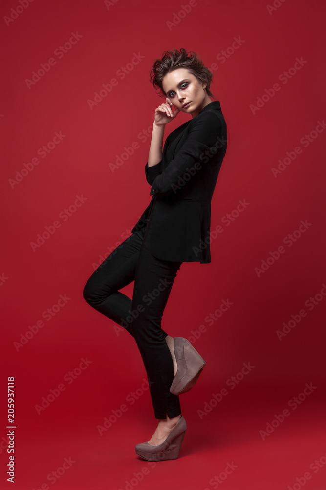 portrait of young girl in black suit on red background standing portrait of young girl in black suit on red background standing