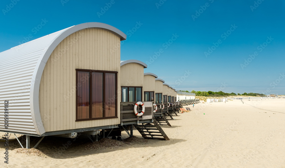 Row of Holiday houses on the beach of Vrouwenpolder, the Netherlands Row of Holiday houses on the beach of Vrouwenpolder, the Netherlands