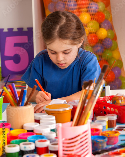 Small student painting in art school class. Child drawing by paints on table in kindergarten. Drawing education develops creative abilities of children. Competition of children's creativity.