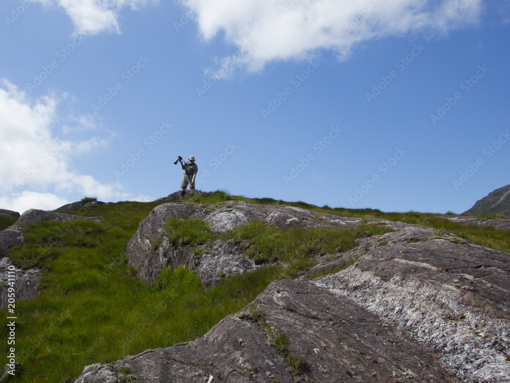 Mature hipster in mountains take a picture in scottish landscape