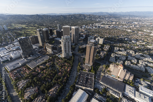 Aerial view of Los Angeles Century City towers and Olympic Bl with Beverly Hills and the Santa Monica Mountains in background. © trekandphoto