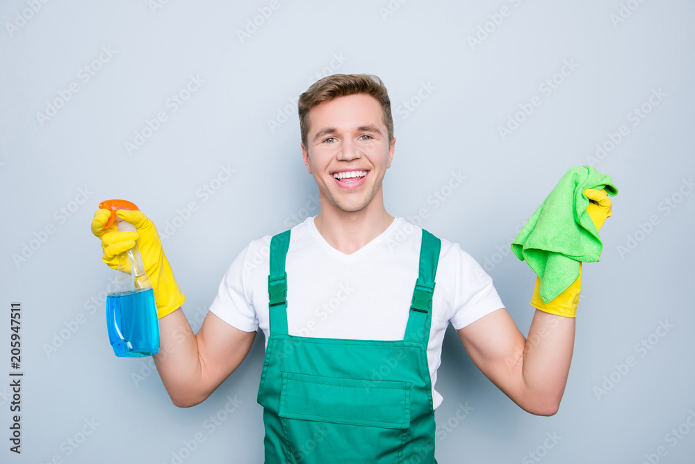 Surface people purity people container professional person concept. Portrait of friendly cheerful excited joyful cleaner showing holding fiber duster and spray in bottle isolated on gray background Surface people purity people container professional person concept. Portrait of friendly cheerful excited joyful cleaner showing holding fiber duster and spray in bottle isolated on gray background