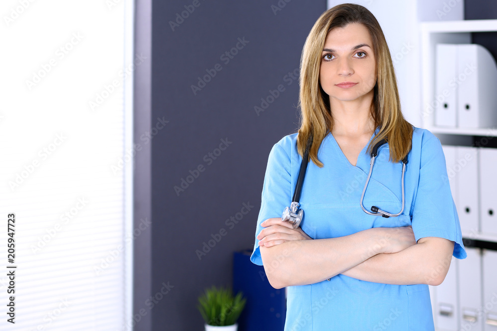 Woman doctor at work in hospital office. Portrait of female physician with arms crossed. Medicine and health care concept Woman doctor at work in hospital office. Portrait of female physician with arms crossed. Medicine and health care concept