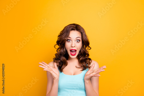 Portrait of scared mad girl yelling with wide open mouth isolated on yellow background. Sale discounts advertisement concept