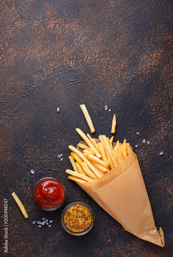 French fries in a paper bag with sauces photo