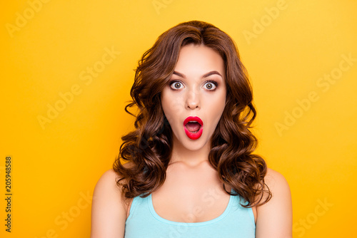 WTF  OMG  Portrait of shocked astonished girl with modern hairdo having wide open mouth eyes looking at camera isolated on yellow background