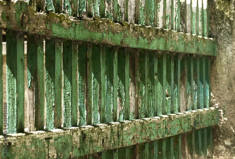 Fototapeta premium Old grunge vintage weathered wooden faded pale cracked painted green boards house garden fence closeup as urban background