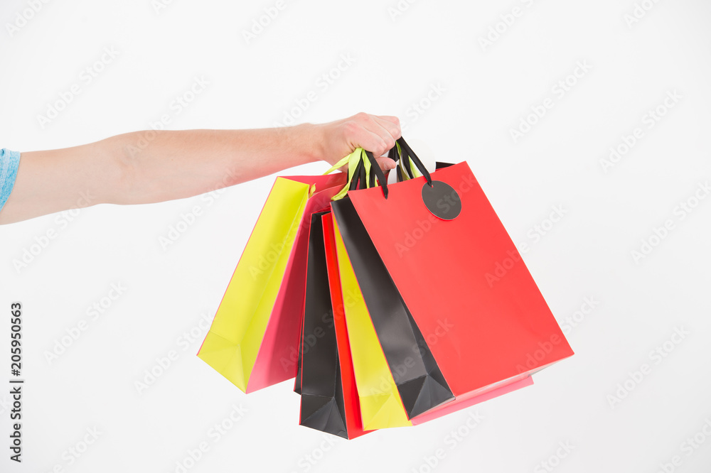 Shopping bags in hand. Paper bags of different colors. Bags or paperbags isolated on white. Shopping during sale and black friday concept. Holidays preparation and celebration. Gift and present