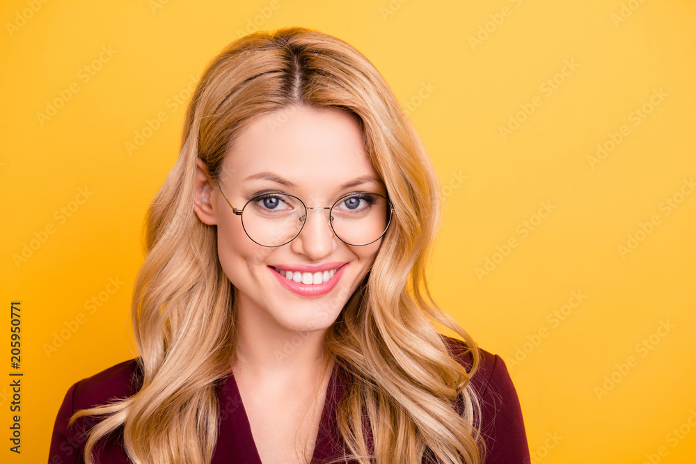 Head shot portrait of cheerful nice woman with white beaming smile in glasses looking at camera isolated on yellow background