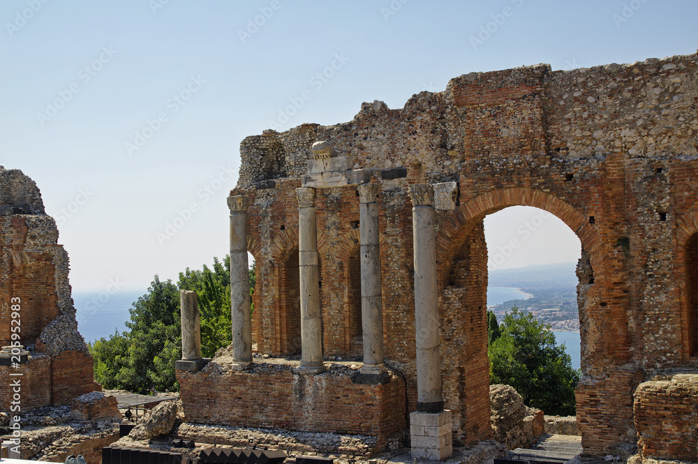 Ruins of the Greek Roman Theater destroyed with Etna erupting, Taormina, Sicily, Italy