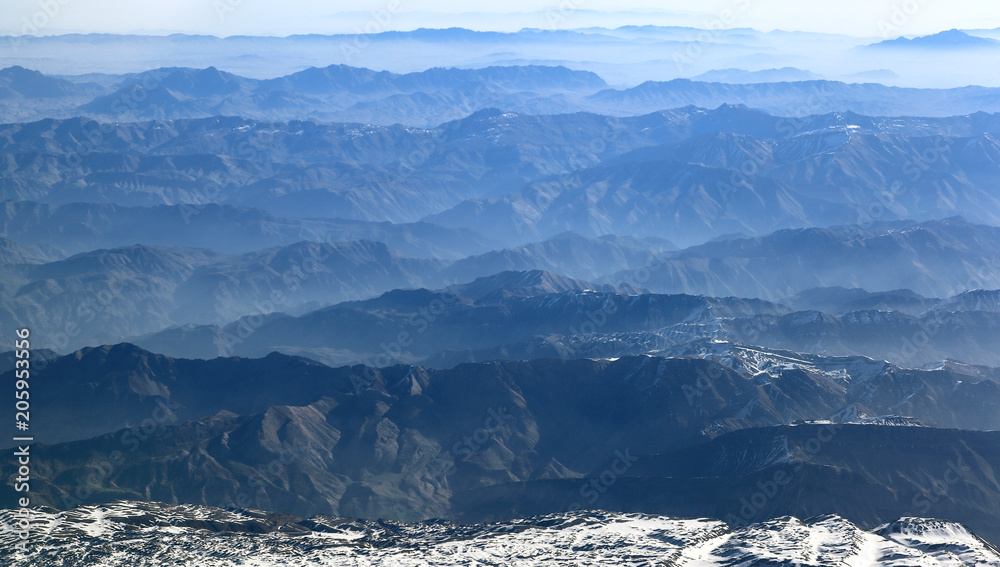 
    Aerial view of mountain ranges receding to the horizon 