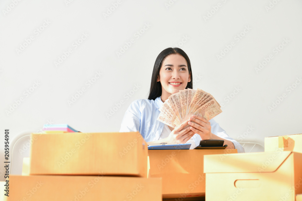 Sme business concept. Young people are packing their packages.Delivery business Small and Medium Enterprise (SMEs). Young Owner Start up for Business Online. Beautiful girls are counting money. Sme business concept. Young people are packing their packages.Delivery business Small and Medium Enterprise (SMEs). Young Owner Start up for Business Online. Beautiful girls are counting money.