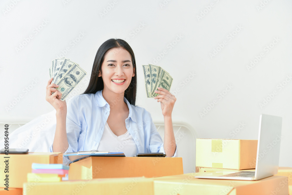 Sme business concept. Young people are packing their packages.Delivery business Small and Medium Enterprise (SMEs). Young Owner Start up for Business Online. Beautiful girls are counting money. Sme business concept. Young people are packing their packages.Delivery business Small and Medium Enterprise (SMEs). Young Owner Start up for Business Online. Beautiful girls are counting money.