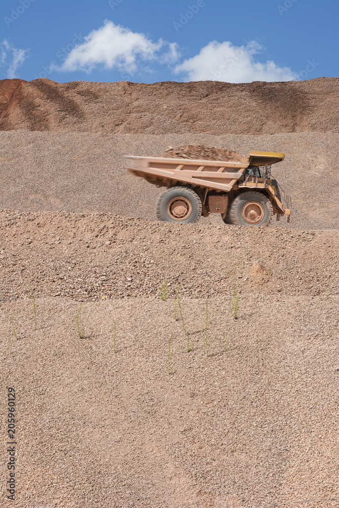 Slopes of an open-pit mine where huge dump trucks are used to uncover precious metals