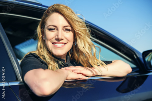 Smiling woman in the car on a summer day.