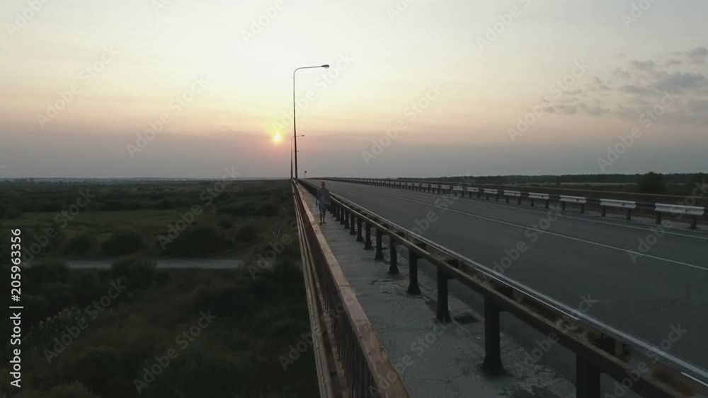 Unknown man walks along the bridge Unknown man walks along the bridge