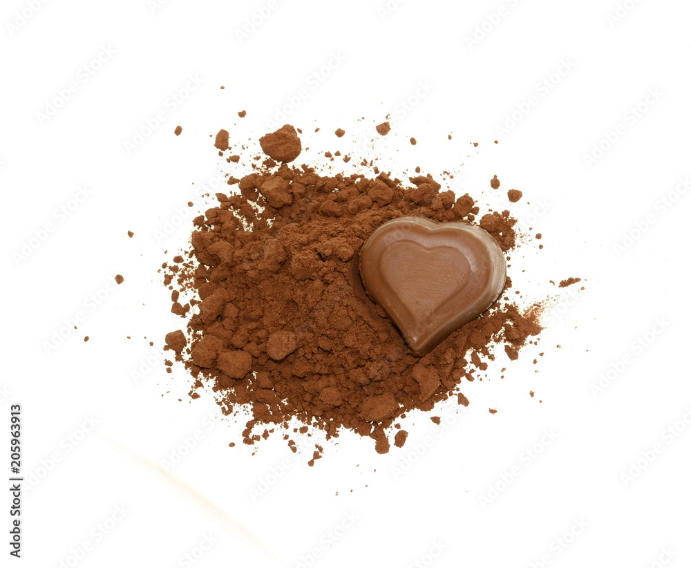 Chocolate heart-shaped candy on a cocoa powder isolated on white.