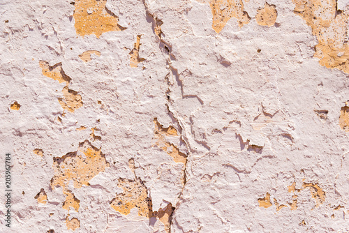 Old flaky paint peeling off on old wall, cracks and scrapes on the surface