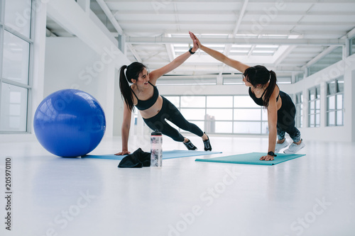 Fototapeta Naklejka Na Ścianę i Meble -  Women working out together at fitness studio