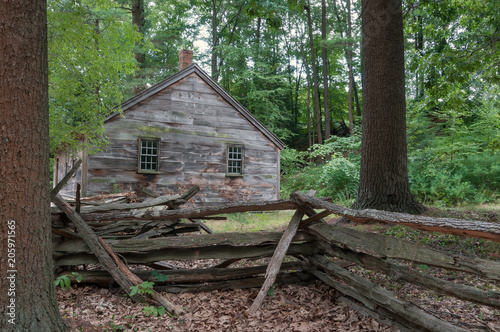 Old Abandoned Cabin in the Woods Surrounded by a Split Rail Fence in New England