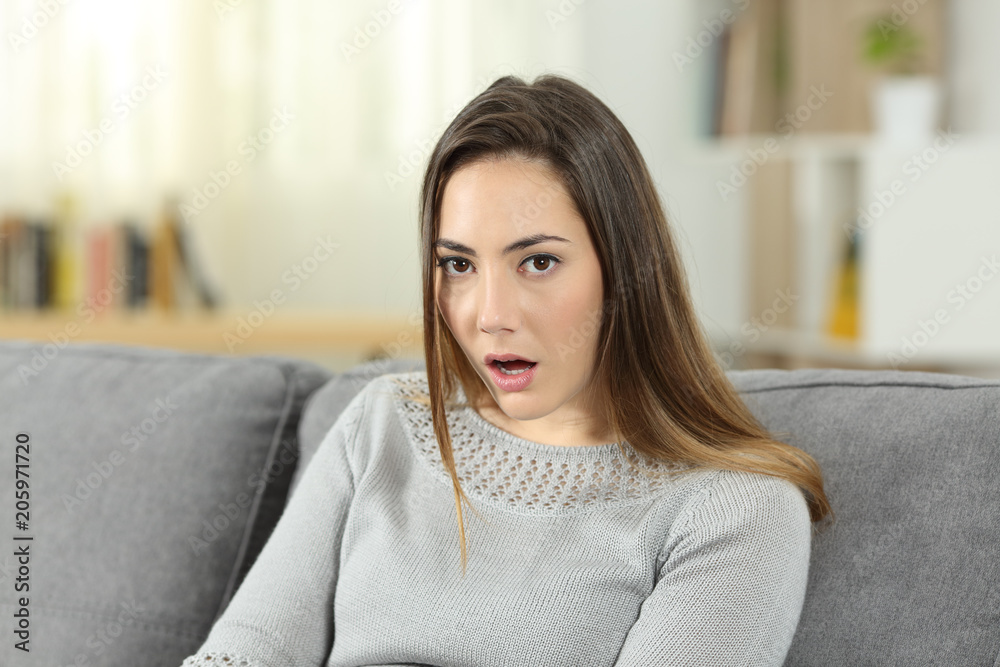 Perplexed woman looking at camera at home Perplexed woman looking at camera at home