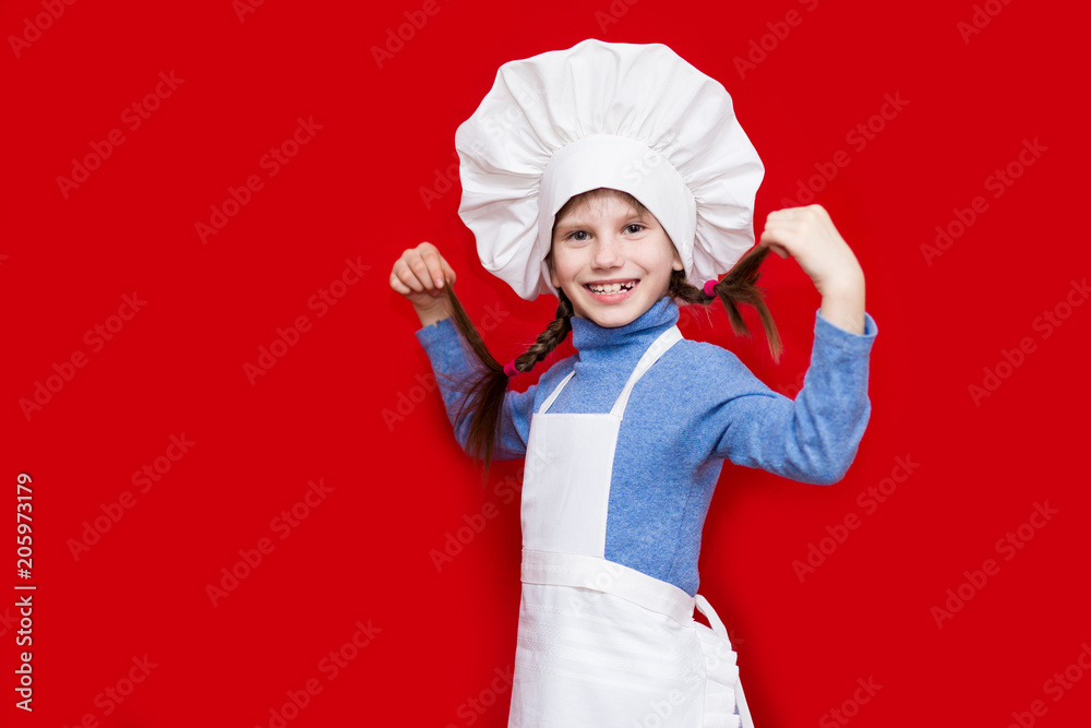 Portrait of beautiful little girl in form of cook isolated on red. Kid chef. Cooking Process Concept Portrait of beautiful little girl in form of cook isolated on red. Kid chef. Cooking Process Concept