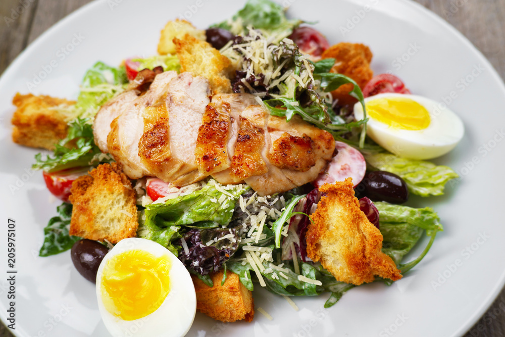Caesar salad with fried chicken meat, close up. Mediterranean cuisine, side dish, appetizer, banquet, restaurant menu concept Caesar salad with fried chicken meat, close up. Mediterranean cuisine, side dish, appetizer, banquet, restaurant menu concept