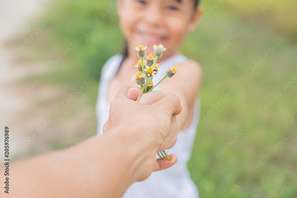 Happy asian little girl giving flower to her mother with love in vintage color tone Happy asian little girl giving flower to her mother with love in vintage color tone