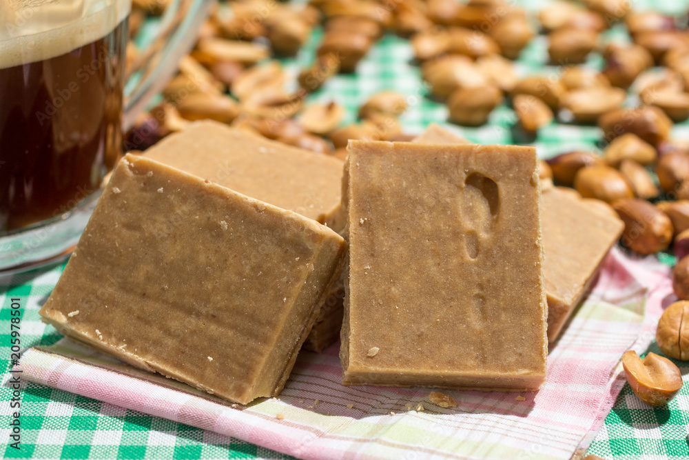 Pacoca is a candy with peanuts from Brazil. Sweet food of Festa Junina, a typical brazilian party. Snack on wicker basket and green background. Cup of coffee Pacoca is a candy with peanuts from Brazil. Sweet food of Festa Junina, a typical brazilian party. Snack on wicker basket and green background. Cup of coffee