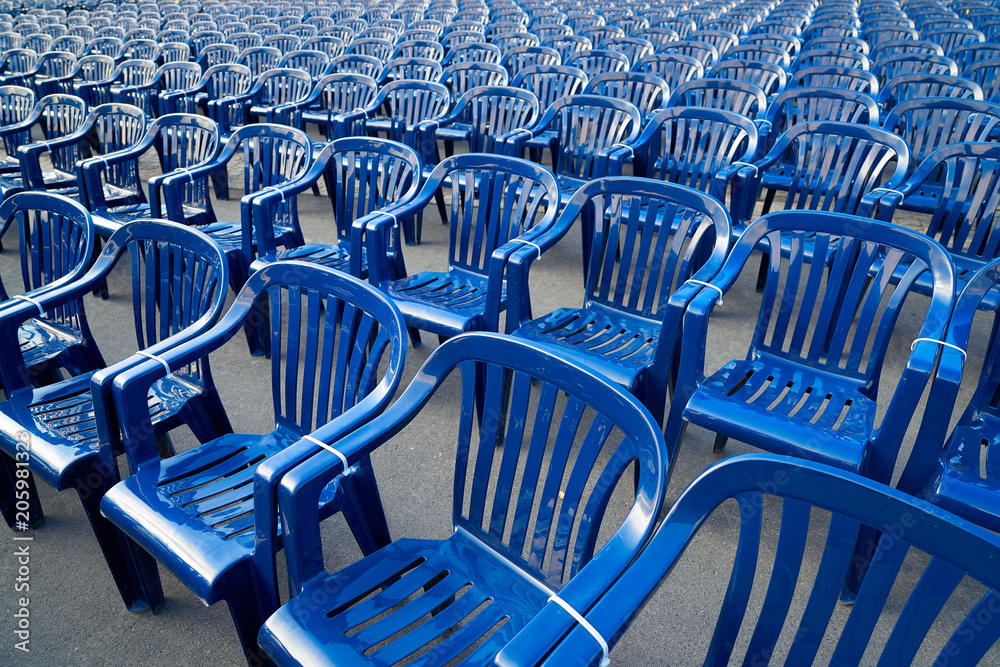 Fototapeta premium Plastic hire chairs in a row blue color