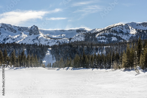 View of Twin Lakes frozen in winter with Mammoth Rock in background in Mammoth Lakes, California