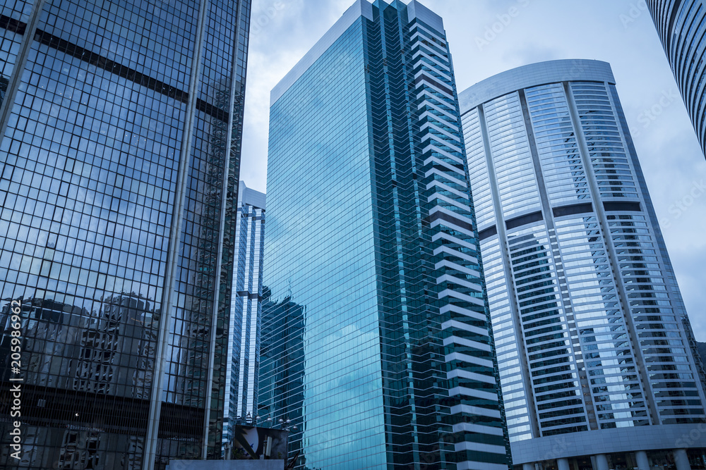 Obraz premium Bottom view of modern skyscrapers in business district against blue sky