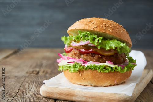 Hamburger with pickled cucumbers, onions, cheese, lettuce and tomato sauce