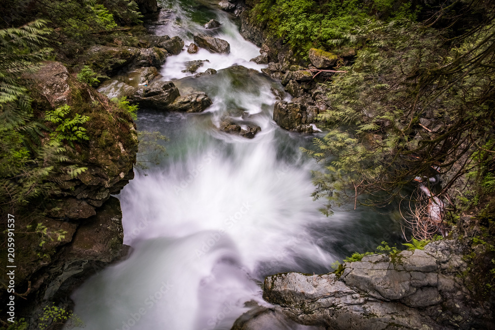 water rushing down a cascading waterfall inside forest water rushing down a cascading waterfall inside forest