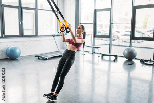 asian female athlete training with resistance bands at gym © LIGHTFIELD STUDIOS
