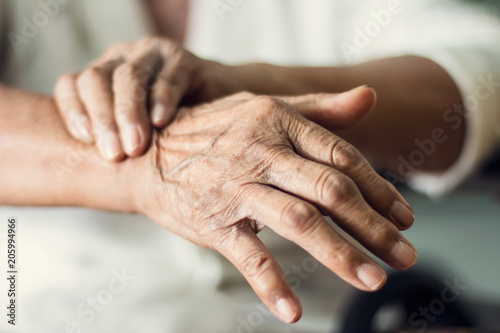 Close up hands of senior elderly woman patient suffering from pakinson's desease symptom. Mental health and elderly care concept photo