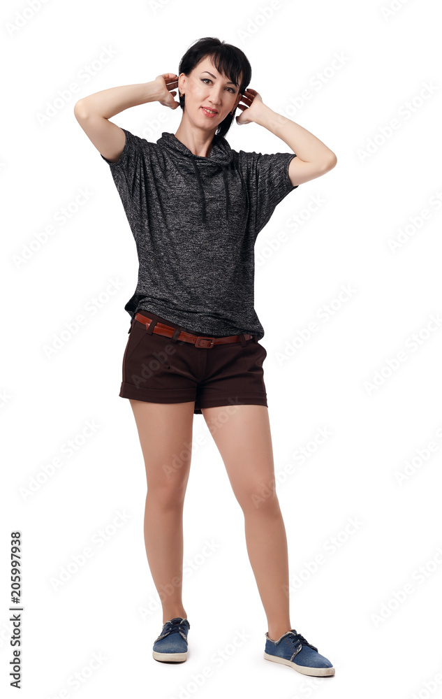 Fototapeta premium young woman posing in studio on white background, wearing brown shorts and shirt
