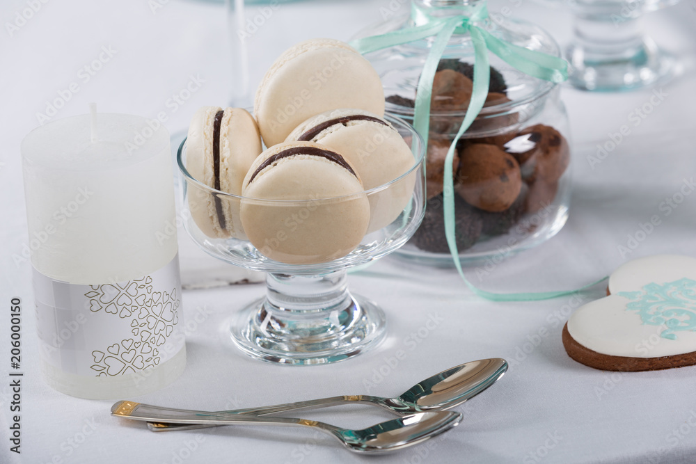 macarons in a glass crockery, next to other sweets and desserts, festive table macarons in a glass crockery, next to other sweets and desserts, festive table