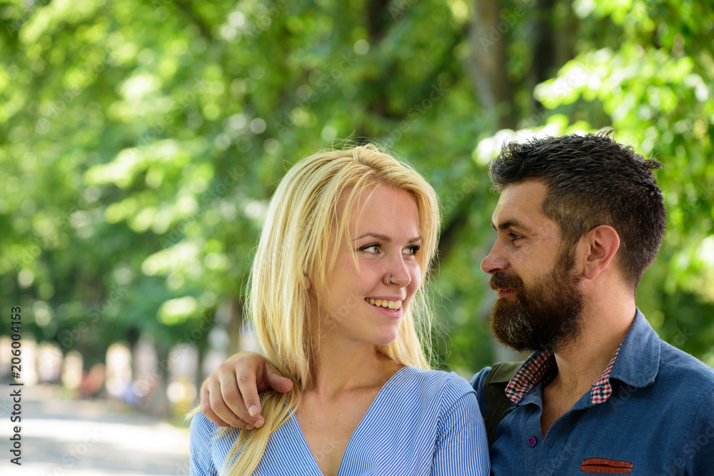 Man hugs happy blonde girlfriend, put hand on her shoulder. Man hugs happy blonde girlfriend, put hand on her shoulder.